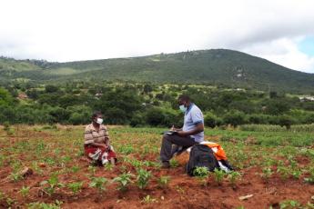 Queen's PhD student interviews tomato farmer in Tanzania