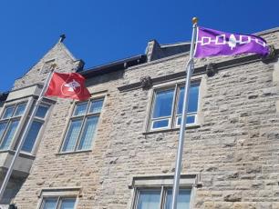 The Anishnaabe and Haudenosaunee flags located in front of Richardson Hall.