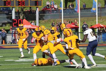 "Queen's Gaels football players grab a turnover again the Laurier Hawks"