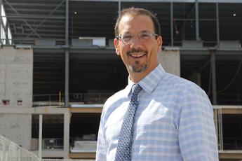 "Dean of the Faculty of Engineering and Applied Science Kevin Deluzio stands outside the construction site for the Innovation and Wellness Centre"