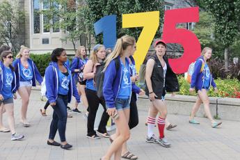An Orientation group walks past the 175 anniversary numbers on campus.