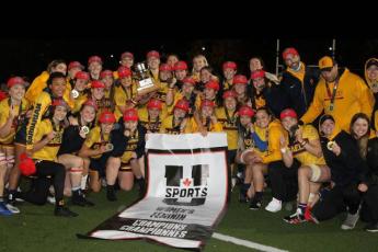 Queen's Gaels women's rugby team pose with the USPORTS championship banner