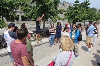"Students and their families listen to a guide during a campus tour as part of Summer Orientation to Academics and Resources"