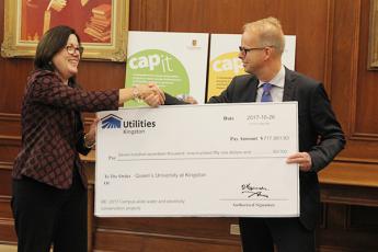 Donna Janiec, Vice-Principal (Finance and Administration) accepts a cheque from Sean Meleschuk, Vice-President of Utilities Kingston.