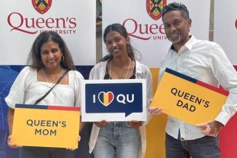 Photograph of an incoming first-year Queen's with their parents during the Summer Orientation to Academics and Resources