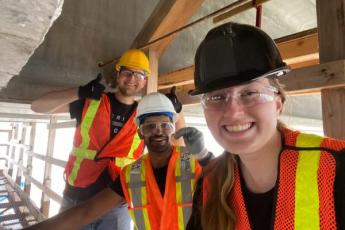 Photograph of Queen's post-doctoral fellow and students underneath the Waaban Crossing bridge.