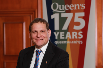 Principal Daniel Woolf with the Queen's 175th banner