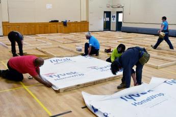 A team from Habitat from Humanity help build pods for Kingston Youth Shelter in Queen's University's McGillivray-Brown Hall.