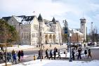Students walk in front of Ontario and Grant halls with snow on the ground.