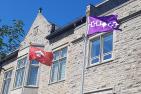 Anishinaabek and Haudenosaunee flags flying outside Queen's Richardson Hall.