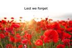 a field of red poppy flowers. words reading "lest we forget"