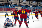 three women's hockey players celebrating a goal