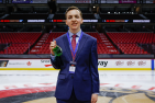 Young man standing at centre ice with a medal