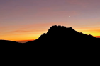 Silhouette of a mountain against the sunset and clouds 