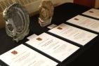Award certificates and sculptures on a table