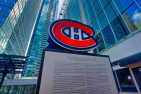 Montreal Canadians' logo on a monument against tall buildings