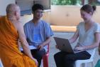 Queen's student Emese Elkind speaks with a monk and a member of BCMF