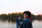 three people standing on pier by the lake.