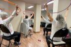 A group of adults participate in a hoop fitness class