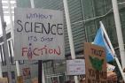Cardboard sign that says 'without science it's just fiction"