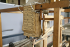 Old fashion punch card hanging from a wooden frame
