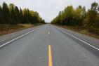 A smooth road cuts through the wilderness of northern Ontario.