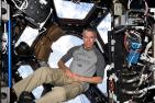 [Dr. Feustel floats above the Earth (Photo: University Relations)]