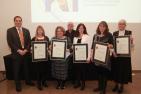 "Group of award winners hold up their certificates"