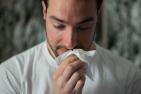 A man wipes his nose due to allergies 