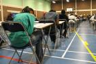 Students write a university entrance exam in a gymnasium.