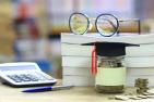 A pair of eye-glasses on top of a stack of three books.