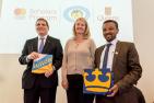 "Queen’s Principal Daniel Woolf, Kim Kerr, Deputy Director, Education and Learning, Mastercard Foundation and Asrat Atsedewoyin, Vice-President Academic, University of Gondar exchange university flags to mark the partnership."