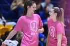 Women's basketball team players wear pink Shoot for the Cure warmup shirts.