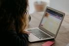 A teen girl uses a laptop computer