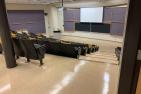 Photograph of a lecture hall with markers on seats to promote physical distancing.