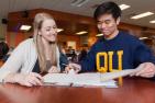 Two students talking at a table.