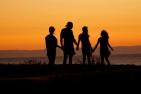 [A group of four people staring at a sunset by Mike Scheid - Unsplash]