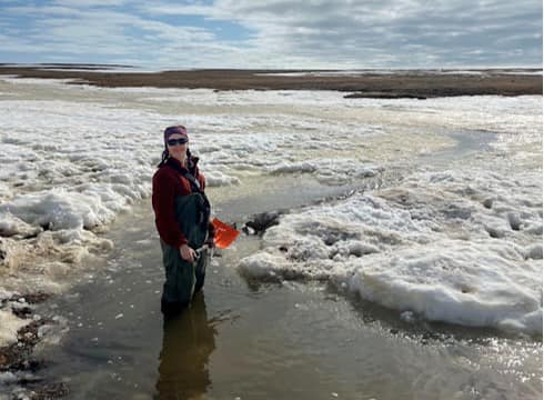 student standing in a frozen river