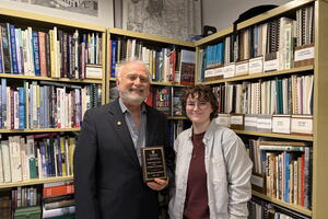 Dr. Dave Gordon (left) is presented with the Julian Szeicz Award for Teaching Excellence by Geography DSC Co-President Chloe Moses (right)