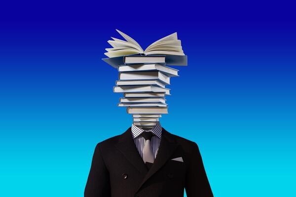 Person in suit with stack of books for a head