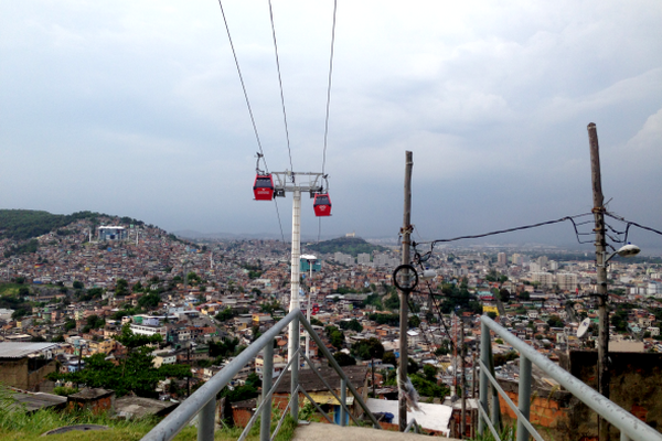 Teleferico gondola cars above crowded urban city