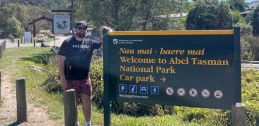 Man standing beside a sign