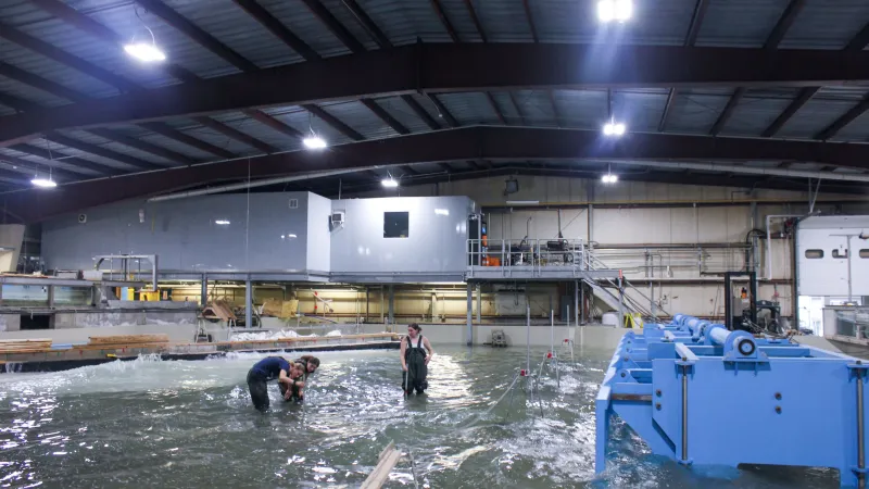 A spacious warehouse alongside a large water tank, illustrating a focus on research and innovation in the industrial sector.