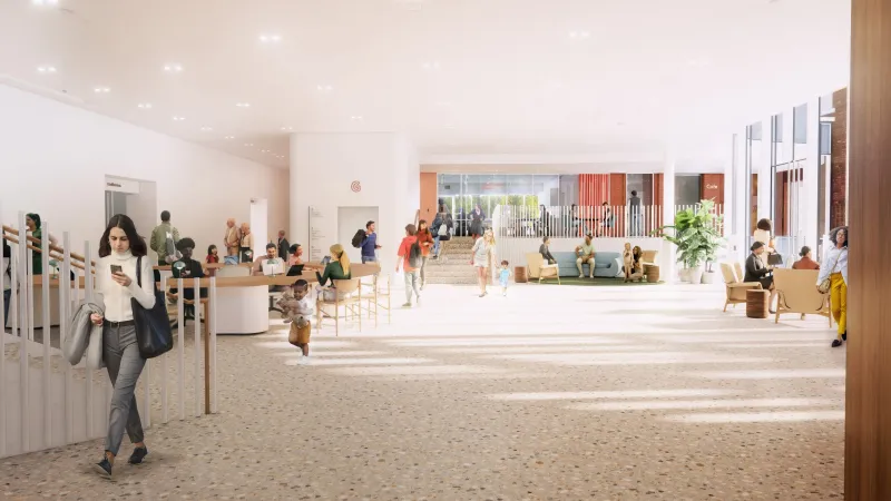 Open view of Queen's University Agnes Centre, portraying an illuminated room with students walking around. 