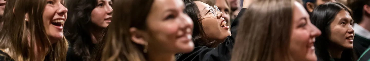 Students smiling and cheering together at convocation, creating a lively and welcoming community atmosphere.