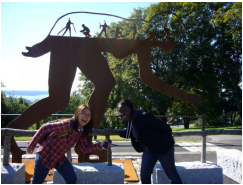 Maame Debrah and a friend pose in front of a sculpture.