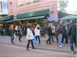 Pedestrians walking along a cobbled street in Oslo.