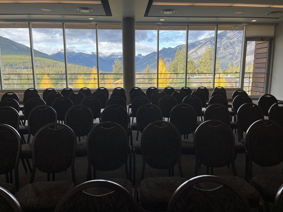 View from the presentation table of a beautiful mountain back drop with fall colored trees we have rows of chairs. Taken at the Banff Centre, for the Arts at the annual UAAC conference. 