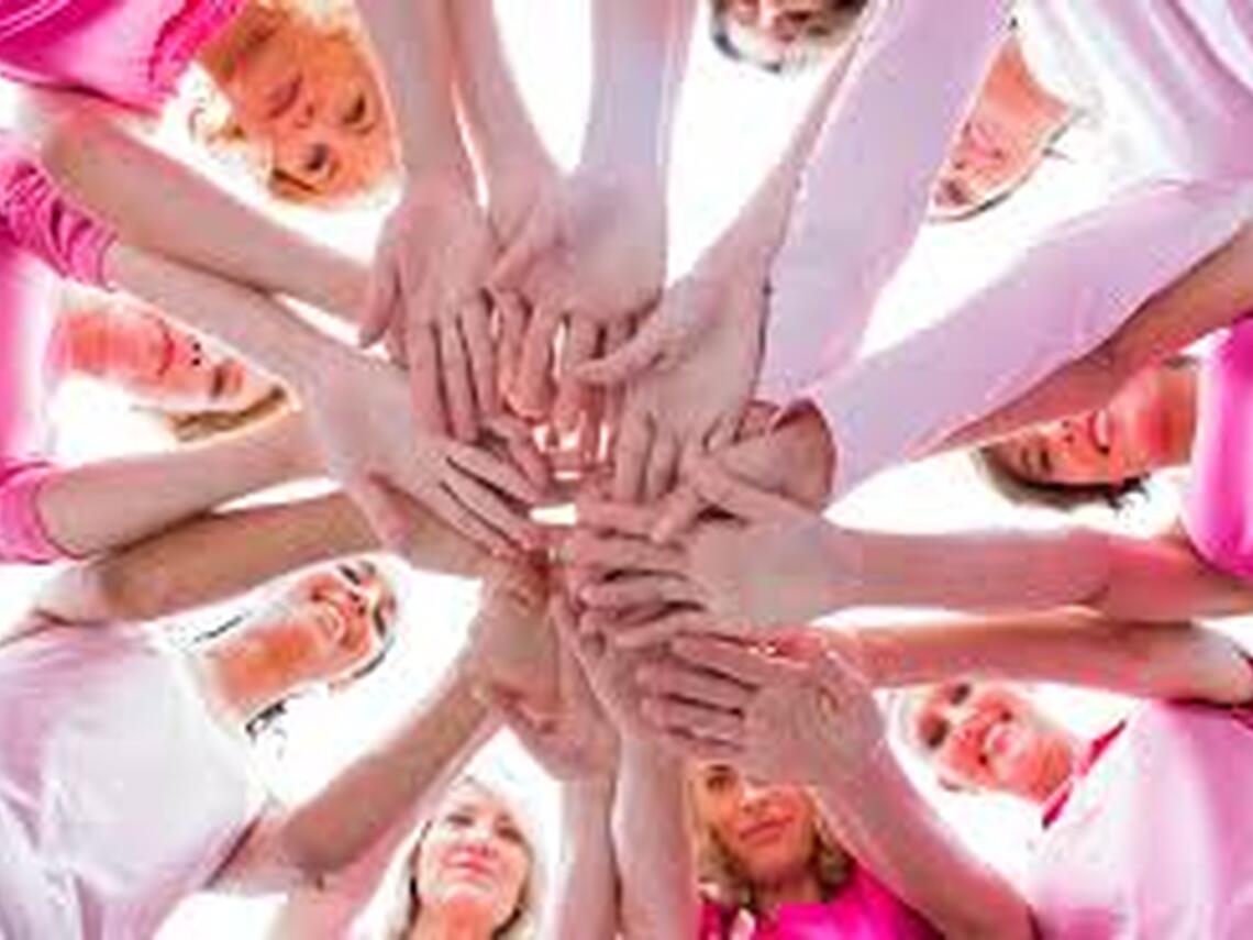 People in pink shirts standing in a circle with hands joined in the centre, symbolizing solidarity for the Day of Pink