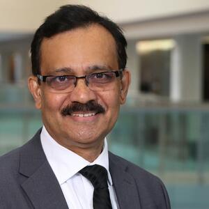 Fahim Quadir standing and smiling.